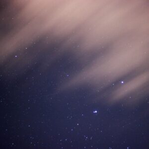 Starry night sky with blurred clouds.